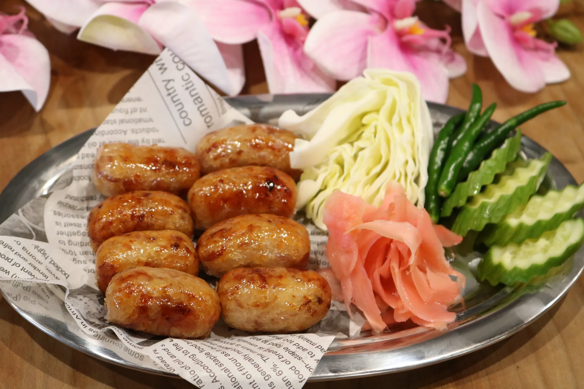 Thai pork sausages served with fresh vegetables